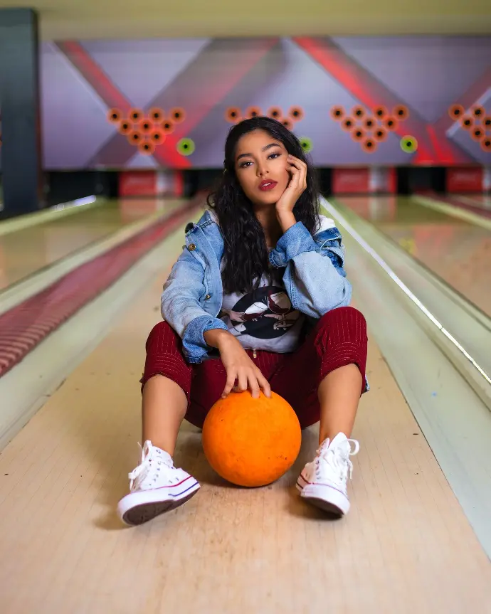 woman in blue denim jacket sitting on brown wooden floor